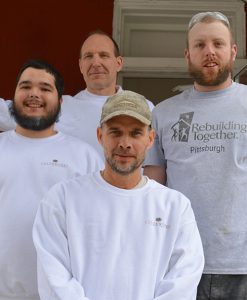 Photo of four male painters on front porch